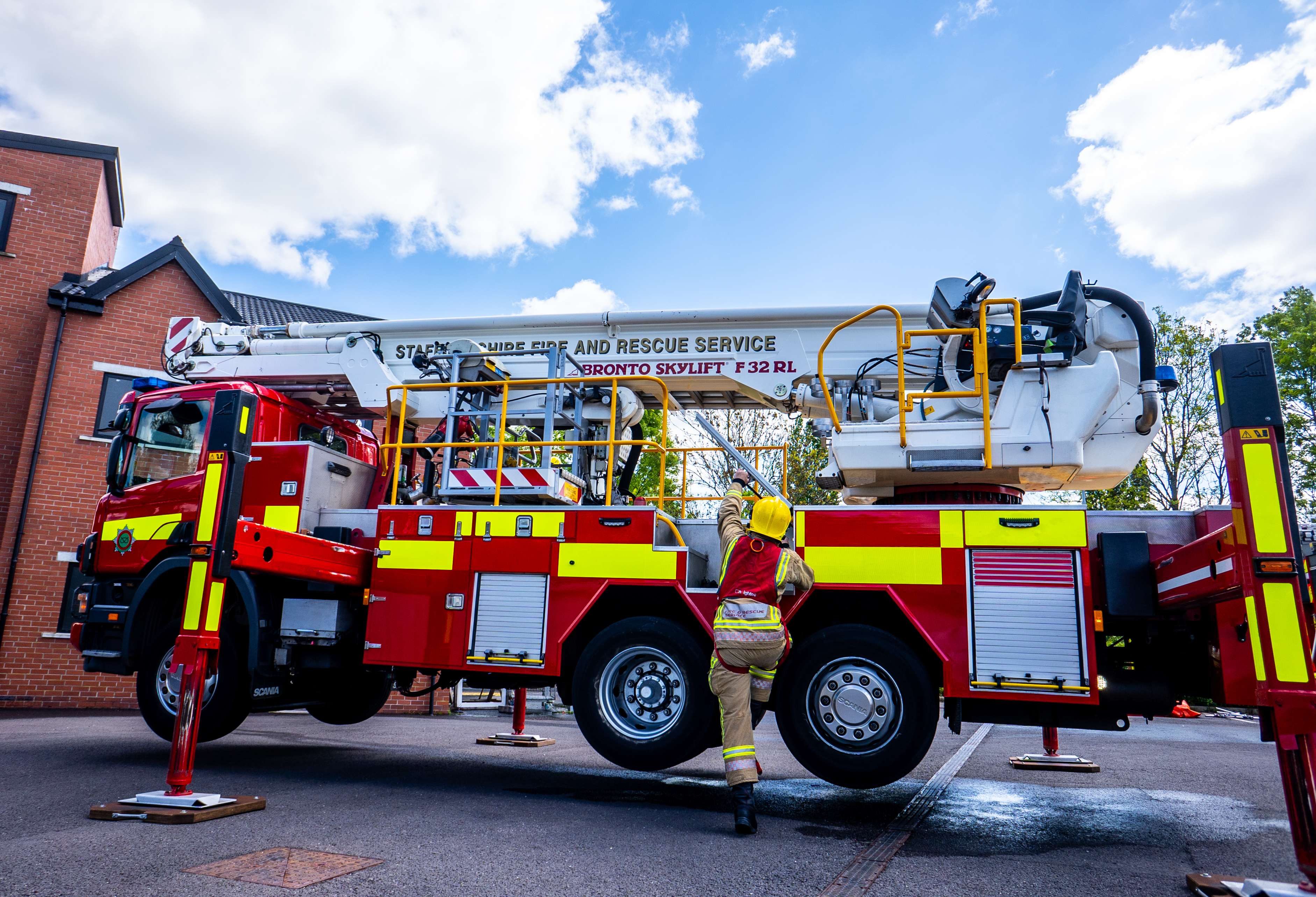 Firefighter climbing onto ALP vehicle