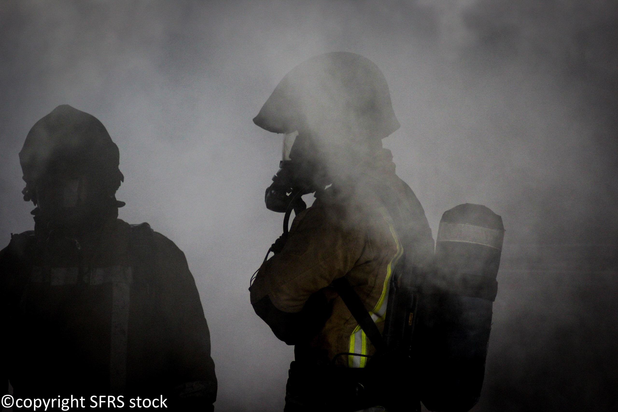 Two firefighter silhouettes in smoke